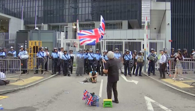 Protestētājs Honkongas centrā vicina Lielbritānijas karogu.