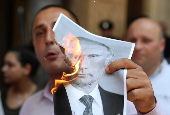 Protestētāji dedzināja fotogrāfijas ar Putina attēlu.