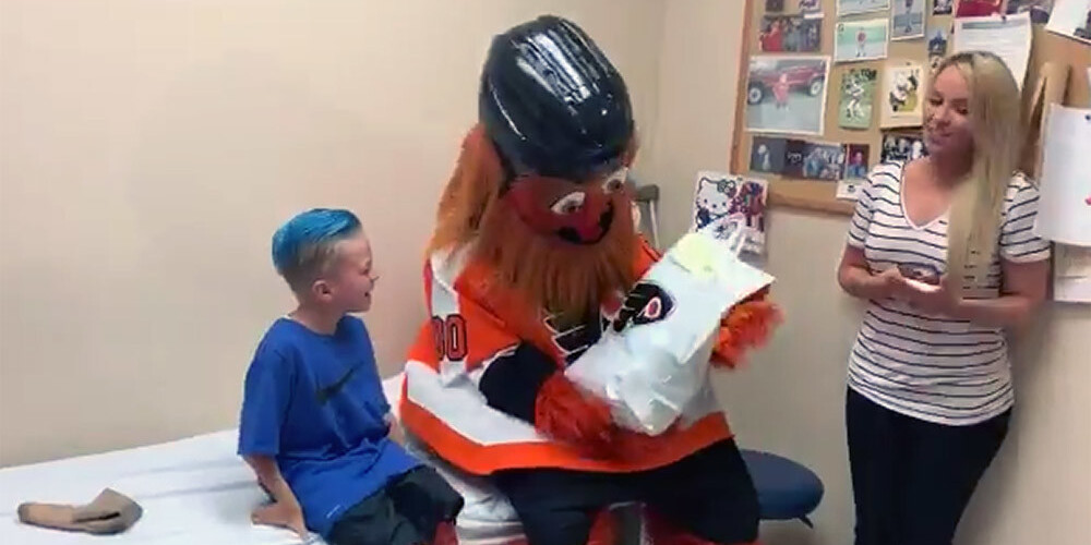 VIDEO: NHL kluba "Flyers" talismans Gritijs slimnīcā iepriecina zēnu ar īpašu kājas protēzi
