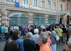 Sākoties garantēto atlīdzību izmaksām, "PNB Bankas" klienti gaida rindā pie bankas galvenās filiāles Raiņa bulvārī.