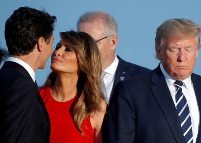 FOTO: ASV pirmā lēdija, stāvot aiz muguras Donaldam Trampam, sniedz skūpstu Kanādas premjerminstram