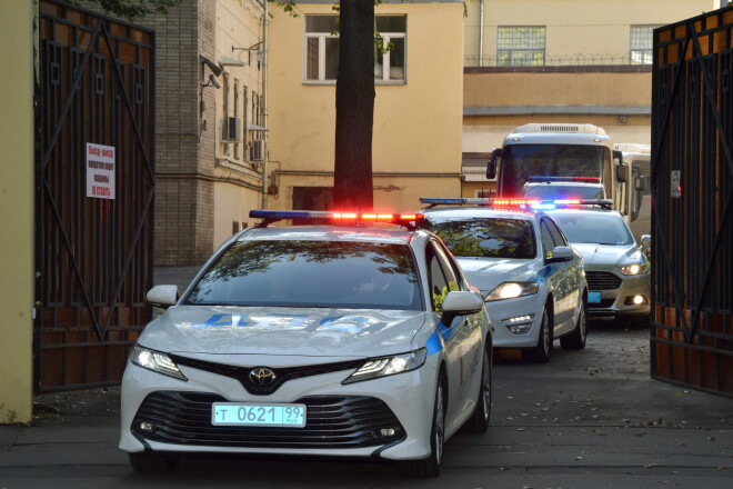 Policijas eskorts un divi autobusi ar aptumšotiem logiem izbrauc no cietuma.