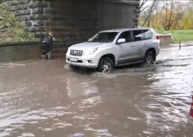 VIDEO: pāri sliedēm vai piesmeltām kurpēm – moderno LU Akadēmisko centru no studentiem šķir milzīga peļķe