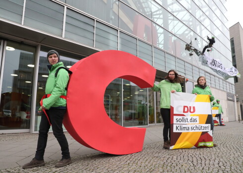 "Greenpeace" norādīja, ka partijas logo "C" burts apzīmē "kristīgo", taču CDU nav īstenojusi pasākumus, lai izglābtu Dieva radīto.