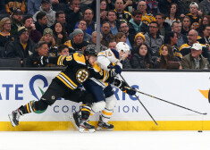 Zemgus Girgensons (pa labi) cīņā ar Bostonas "Bruins" zvaigzni Davidu Pastrņāku.