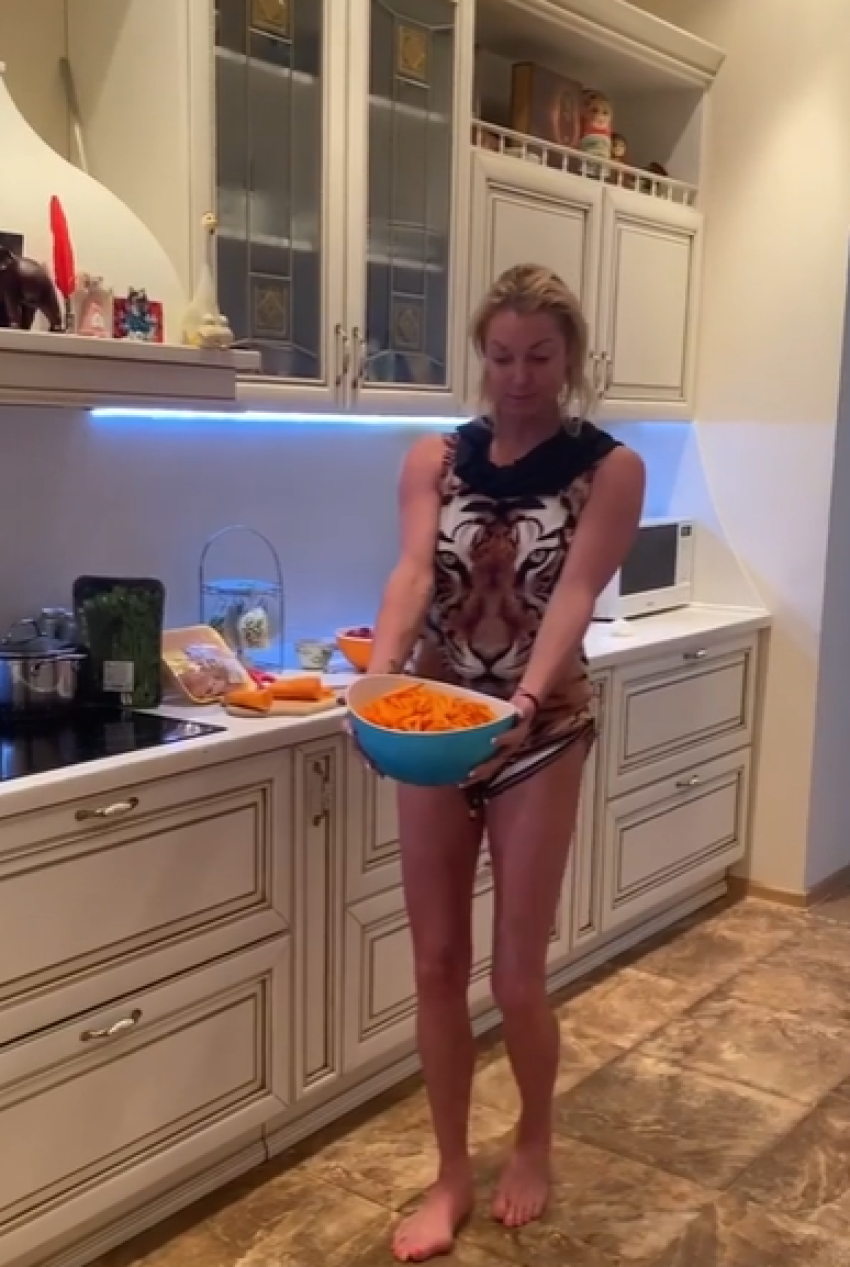 Сексуальная девушка в трусиках и майке готовит завтрак на кухне