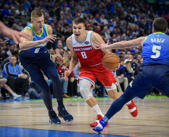 Kristaps Porziņģis aizsardzībā pret serbu basketbolistu Bogdanu Bogdanoviču.