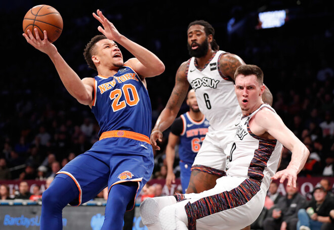 Rodions Kurucs aizsardzībā pret "Knicks" spēlētāju Kevinu Noksu.