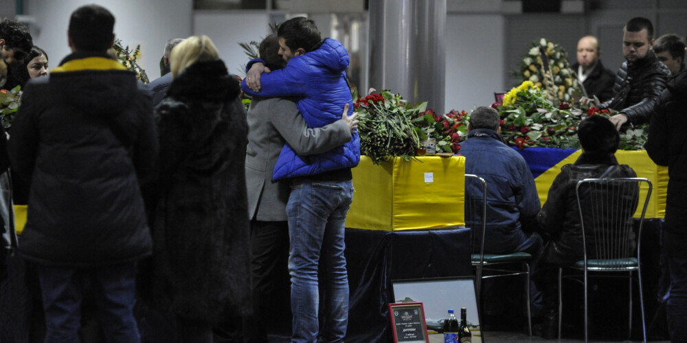 Cilvēki Kijevas lidostā sagaida mājup pārvestos ukraiņus, kuri mira traģiskajā aviokatastrofā