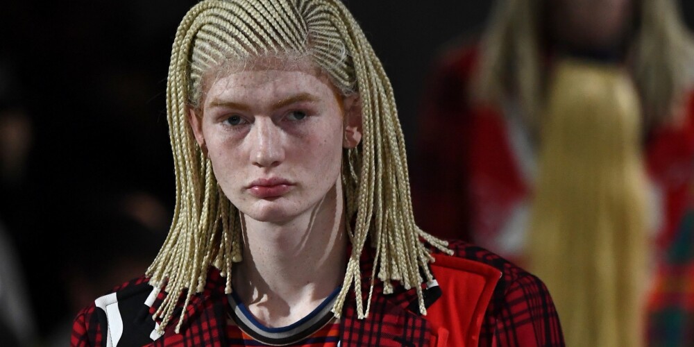 Gaišas ādas krāsas modelis ar skandāla apvīto, smalko bizīšu parūku "Comme Des Garçons" vīriešu modes rudens/ziema skate 2020/2021, Parīzes modes nedēļa.