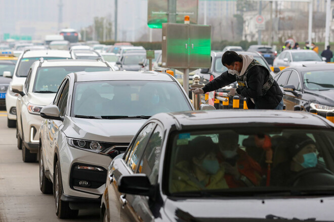 Huangā tiek pārbaudīti visi transportlīdzekļi. Epidēmijas novēršanas grupas darbinieks pārbauda pasažiera ķermeņa temperatūru.