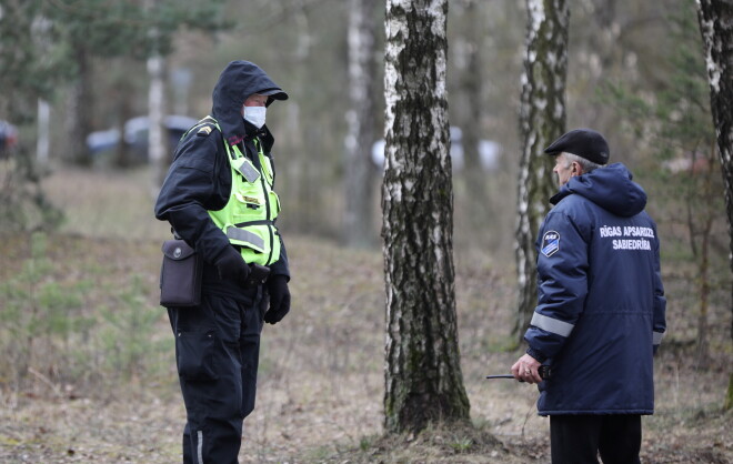 Valsts policijas darbinieks aizsargmaskā pie Latvijas Infektoloģijas centra.