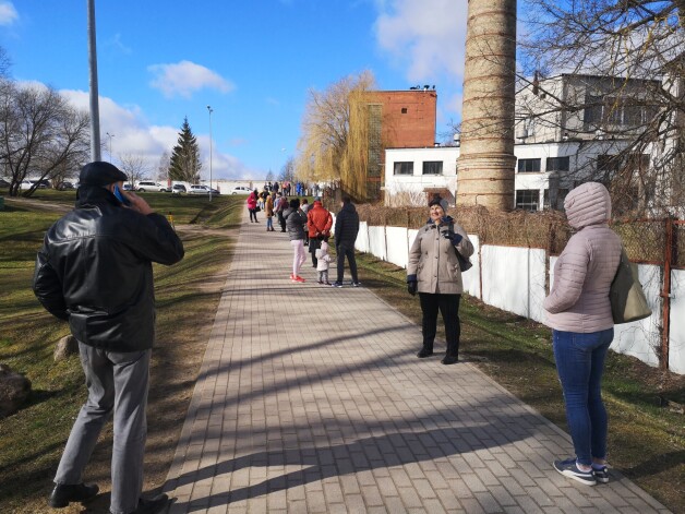 Ievērojot sociālo distanci, pircēji Dobelē stāv rindā uz Spodrības veikalu pēc dezinfekcijas līdzekļiem.