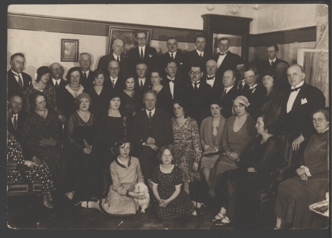 Foto, ko Jānis Danoss tur goda vietā, – apliecinājums Danosu ģimenes labajiem laikiem, kad viņu mājā tika rīkoti augstākās sabiedrības saviesīgie vakari, kuros piedalījās dziedātāji, mākslinieki, uzņēmēji, profesori. Attēla vidū otrajā rindā – pasaulslavenais krievu dziedonis Fjodors Šaļapins, viņam blakus pa labi – Olgas māsa Mērija Sakse, kura tolaik dziedāja operā, priekšā Mērijas meitas. Arpads Danoss – augšā pie spoguļa, Olga – otrā no labās.