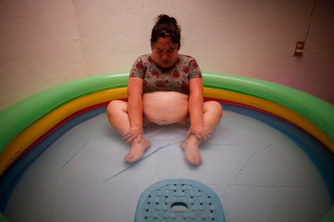 Karla sēž piepūšamajā baseinā, kas piepildīts ar silto ūdeni, un sakopo savas pēdējās spēka pilītes.