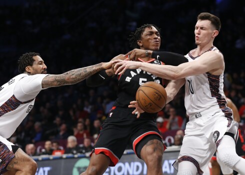 Rodions Kurucs (pa labi) un Vilsons Čandlers (pa kreisi) cenšas apturēt Toronto "Raptors" uzbrucēju Stenliju Džonsonu.