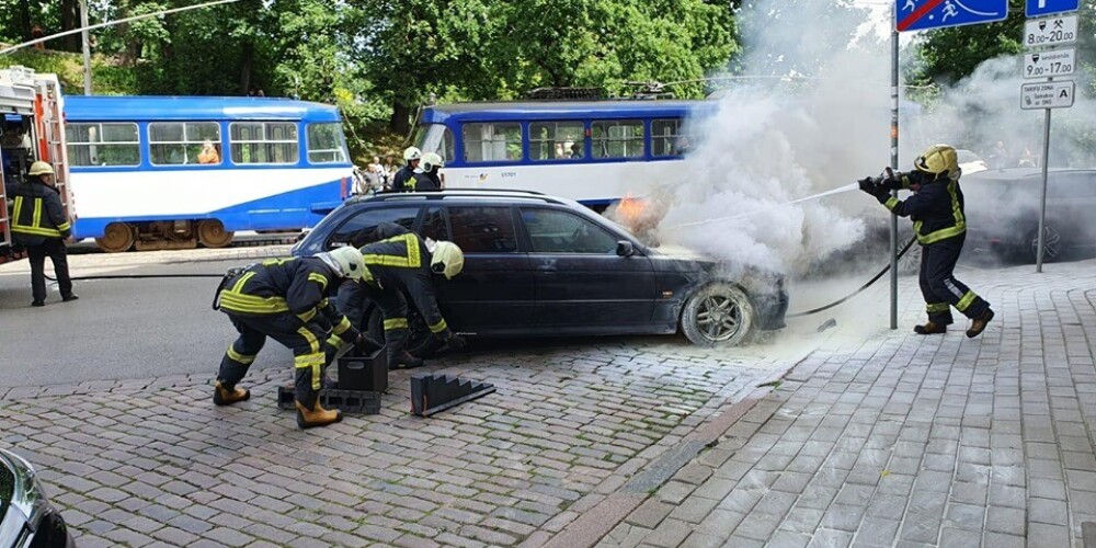 VIDEO: Rīgas centrā pretī Bastejkalnam deg melns BMW