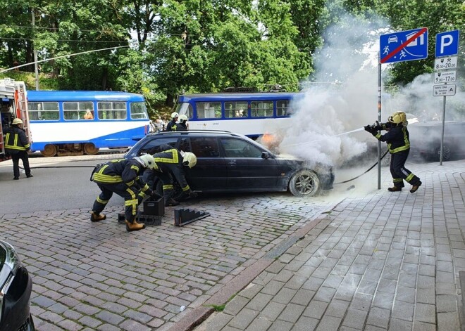 VIDEO: Rīgas centrā pretī Bastejkalnam deg melns BMW