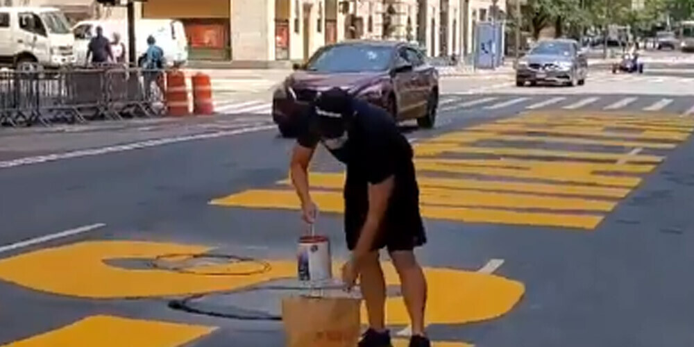 Vīrietis ieradās ar sarkanas krāsas bundžu un aplēja uzrakstu.