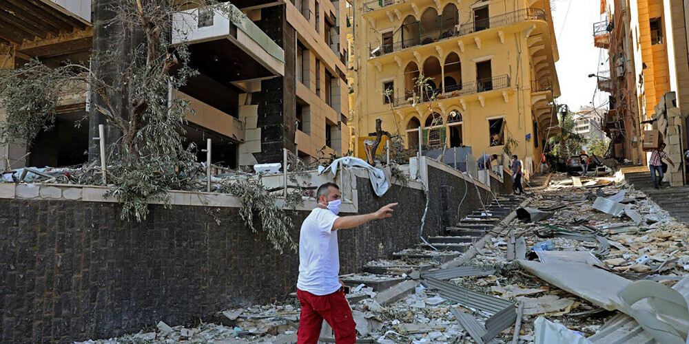 Vīrietis Beirūtā vēro postošā sprādziena radītās sekas.