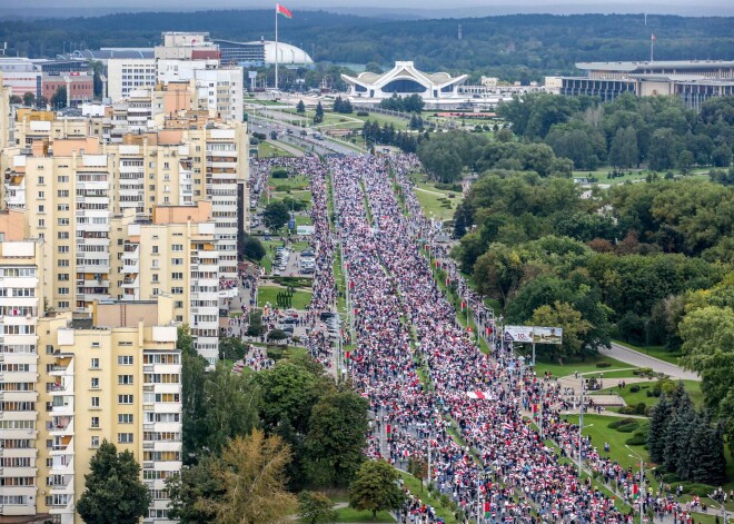 FOTO: protestētāju pūļi Minskā virzās uz policistu sienas ieskauto prezidenta pili