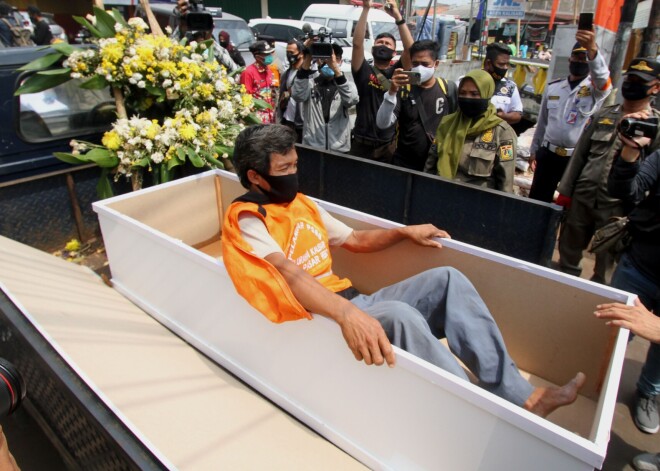 FOTO: Džakartā sejas masku nenēsātājiem draud baiss sods – jāguļas zārkā publiskā vietā un jāskaita līdz 100
