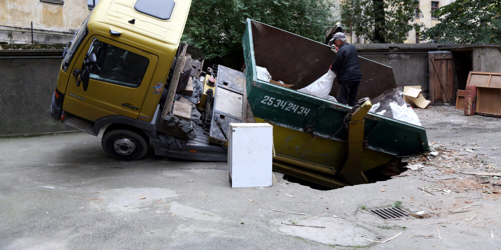 FOTO: Rīgā asfaltā iegruvusi kravas automašīna