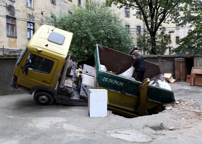 FOTO: Rīgā asfaltā iegruvusi kravas automašīna