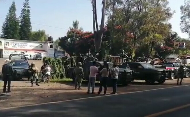 Vietēji iedzīvotāji un policisti pie bāra, kurā tika nogalināti 11 cilvēki.