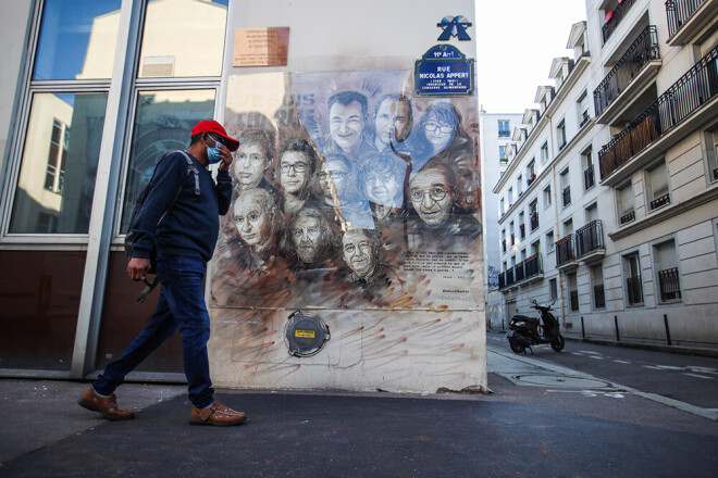 Vīrietis Parīzē iet garām ielu mākslinieka Kristiana Gumī darbam pie "Charlie Hebdo" bijušā ofisa, kur attēloti islāmistu nogalinātie karikatūristi.
