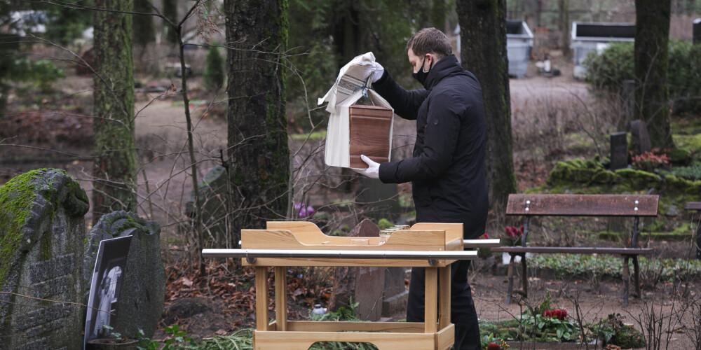 FOTO: Leona Krivāna ģimene urnu ar viņa pelniem apbedī Meža kapos