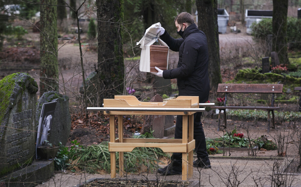 FOTO: Leona Krivāna ģimene urnu ar viņa pelniem apbedī Meža kapos