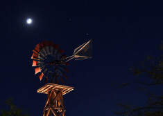 Mēness un planētas Saturns un Jupiters, kas redzamas virs vējdzirnavām Nevadā.