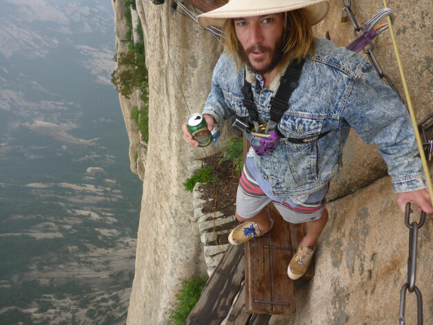 Daring traveller Tyral Dalitz on his round the world journey - he is pictured here on the plank walk of death on Mount Huashan in China. See SWNS story SWTRAVEL A globetrotter travelled 50,000 miles from Australia to America through almost 50 countries - without stepping foot on a plane. Intrepid Tyral Dalitz set off from Sydney and arrived in San Diego 976 days later. The 29-year-old trekked, sailed, hitch-hiked, motorcycled, pedalled, caught trains, buses and drove half way around the world after making a drunken bet with a pal. He slept on strangers’ sofas, camped in the wilderness and picked the "most cheap and dangerous" route because he wanted to have an adventure.