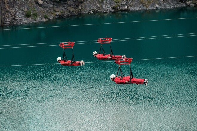 Three people on the Velocirty 2 zip lines at Zip World Penrhyn Quarry, North Wales, UK