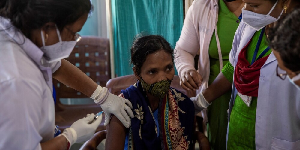 "Lielākā vakcinācijas programma pasaulē" - kā savas potes bruņotu policistu pavadībā saņem indieši