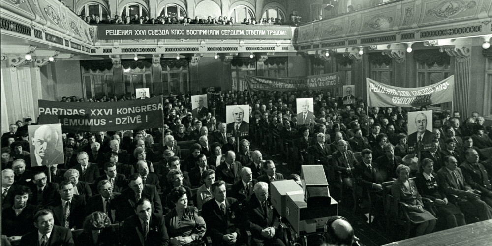 No Padomju Savienības Komunistiskās Partijas (PSKP) ģenerālsekretāra Leonīda Brežņeva Latvijas PSR darbaļaužu saņemtajai vēstulei veltītais darbaļaužu un dažādu organizāciju pārstāvju mītiņš Latvijas Komunistiskās partijas (LKP) Centrālās komitejas Politiskās izglītības namā Andreja Upīša ielā (tagad Skolas iela). Zālē redzami plakāti ar uzrakstu "Partijas XXVI kongresa lēmumus dzīvē!". Rīga, 1981. gada 3. decembris, fotogrāfs Jevgeņijs Fadejevs