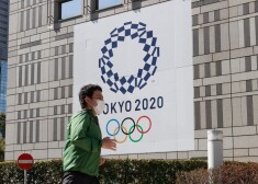 A pedestrian wearing a mask walks by a signage advertising the Tokyo 2020 Olympic Games in Tokyo. 
International Olympic Committee (IOC) President Thomas Bach reiterated that the IOC is fully committed to delivering the Tokyo Games this summer. The opening ceremony is currently scheduled for July 23. (Photo by James Matsumoto / SOPA Images/Sipa USA)