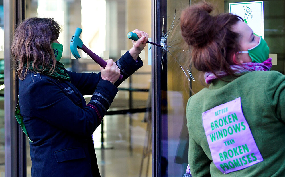Klimata aktīvisti Londonā ar kaltu un āmuru izdauza bankas 