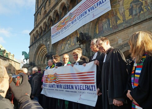 Jau 2015. gadā Brēmenes mācītāji uz pilsētas katedrāles kāpnēm protestēja pret sava amatbrāļa Olafa Lacela nepiedienīgo izrunāšanos.