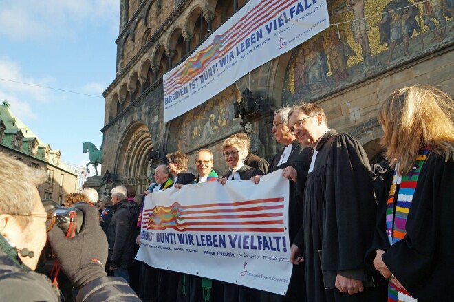 Jau 2015. gadā Brēmenes mācītāji uz pilsētas katedrāles kāpnēm protestēja pret sava amatbrāļa Olafa Lacela nepiedienīgo izrunāšanos.