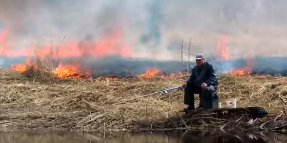 Суровый рыбак попал на видео! Мужчина спокойно сидел с удочкой, пока вокруг бушевал пожар