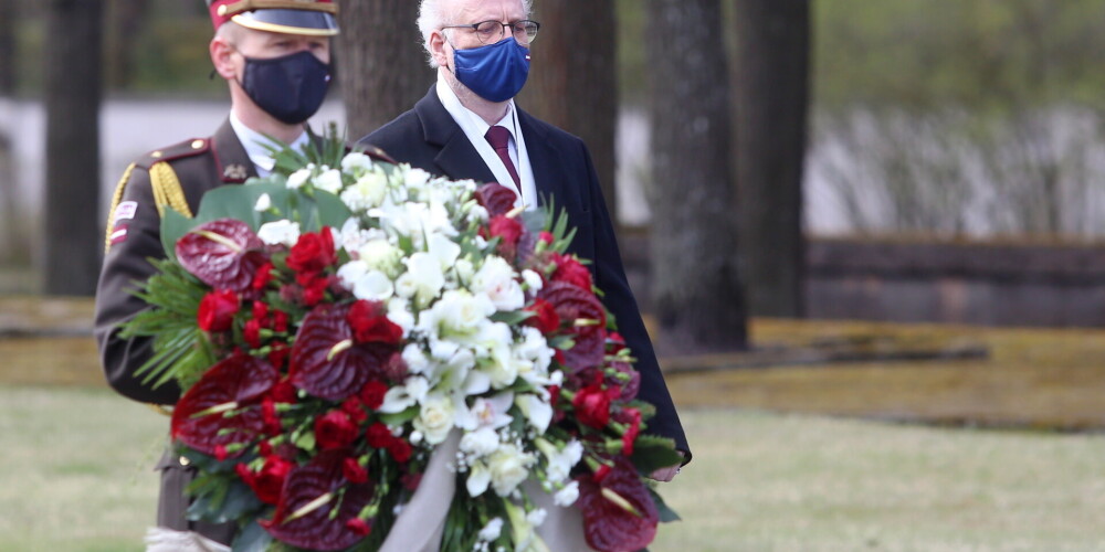 Valsts prezidents Egils Levits (no labās) noliek vainagu Rīgas Brāļu kapos,godinot nacisma sagrāves un Otrā pasaules kara upuru piemiņu