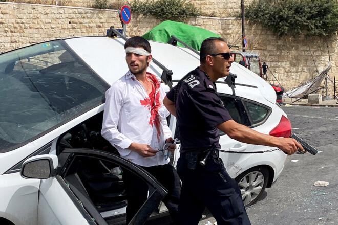 Izraēlas policists pie cietušā tautieša, kurš ar auto uzbrauca palestīnietim.