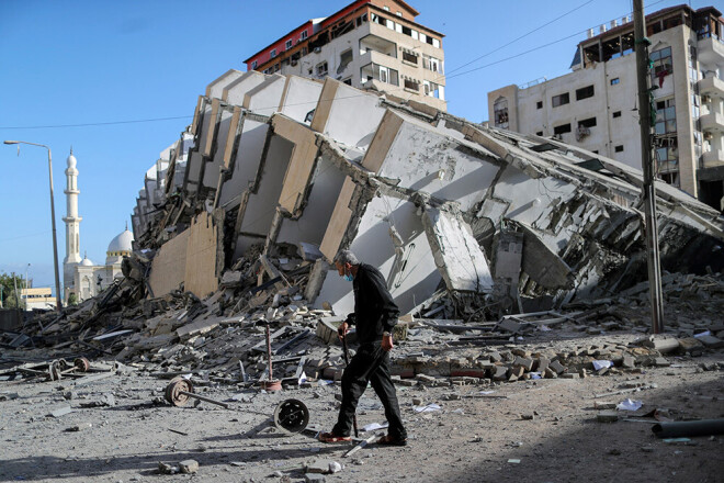 Palestīnietis iet garām augstceltnes drupām, kas tika sagrauta reaktīvo iznīcinātāju triecienos.