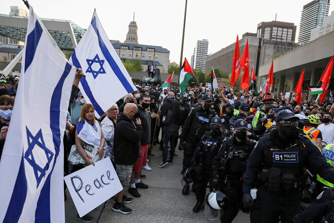 Policisti Toronto stāv pa vidu starp Izraēlas un palestīniešu atbalstītājiem.