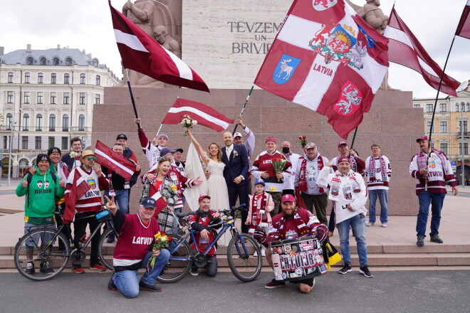 Latvijas hokeja fani dažas stundas pirms spēles starp Latviju un Kanādu, devās gājienā uz Brīvības pieminekli. Jaunlaulātais pāris tur pagadījās neujauši.