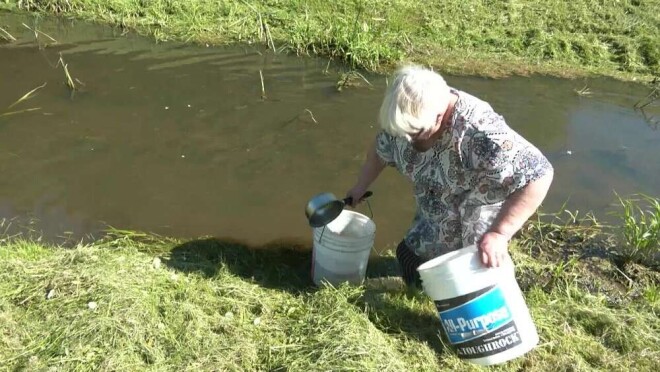 Otrās grupas invalīde Gaļina, kuras dzīvoklī pirms četriem gadiem vietējais komunālo pakalpojumu uzņēmums nepamatoti atslēdza ūdeni, pēc tā spiesta iet uz tuvējo upīti.