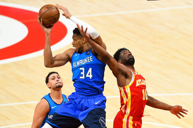 "Bucks" līderis Jannis Adetokunbo (pa kreisi) cīņā par atlēkušo bumbu ar "Hawks" uzbrucēju Solomonu Hilu (pa labi).