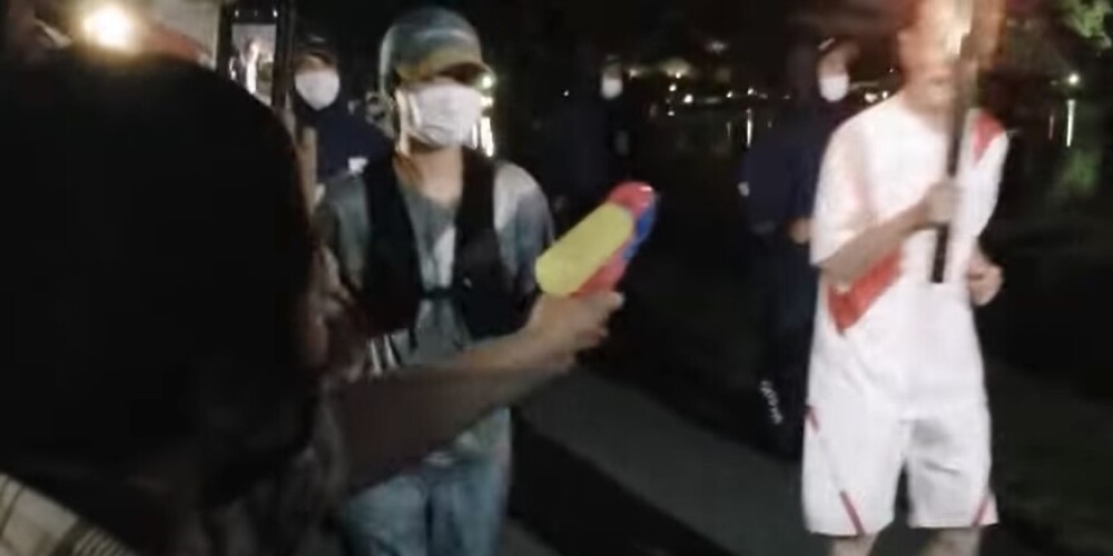 Женщина в Японии попыталась потушить олимпийский огонь водяным пистолетом